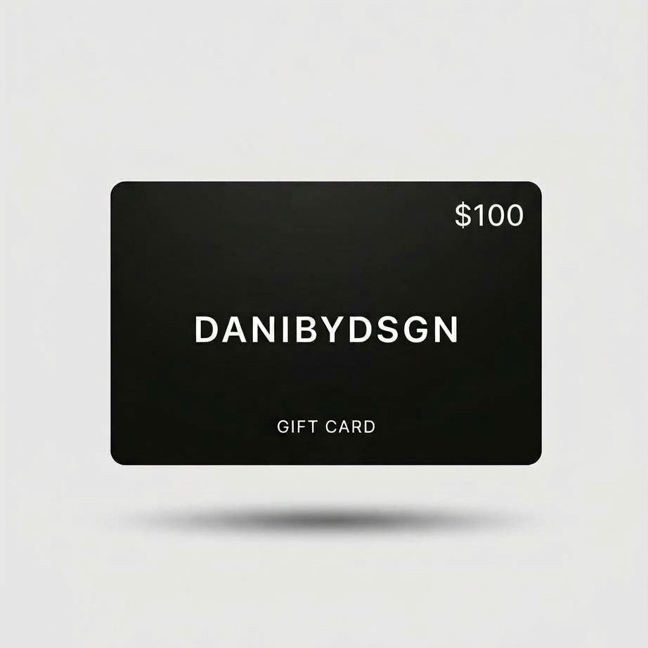 Close up of a Danibydsgn  $100 black digital gift card with 'DANIBYDSGN' branding and $100 in the top right hand corner of the card.  Card is set against a light background.  Digital e-gift cards from Danibydsgn.