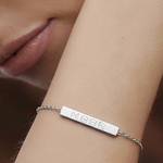 Close-up of the Danibydsgn engravable bar bracelet in 925 sterling silver, featuring a four-symbol geometric logo engraving on the bar plate, worn on the wrist for an elegant, minimalist look.