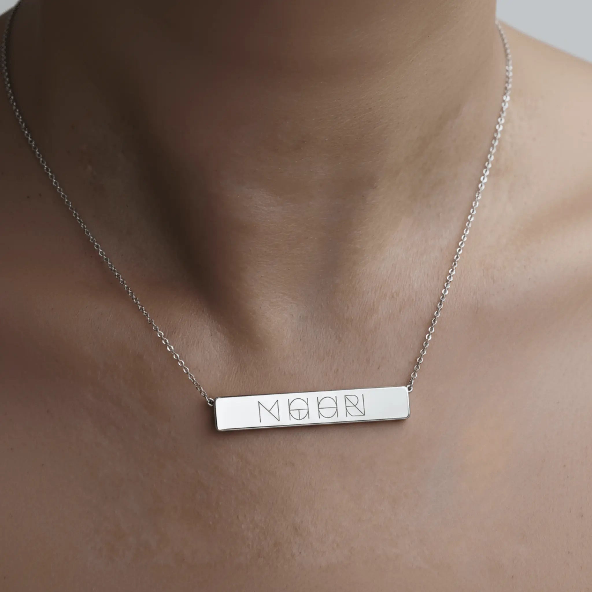 Engraved bar necklace in 925 sterling silver worn by a model, showcasing personalized jewelry by Danibydsgn.