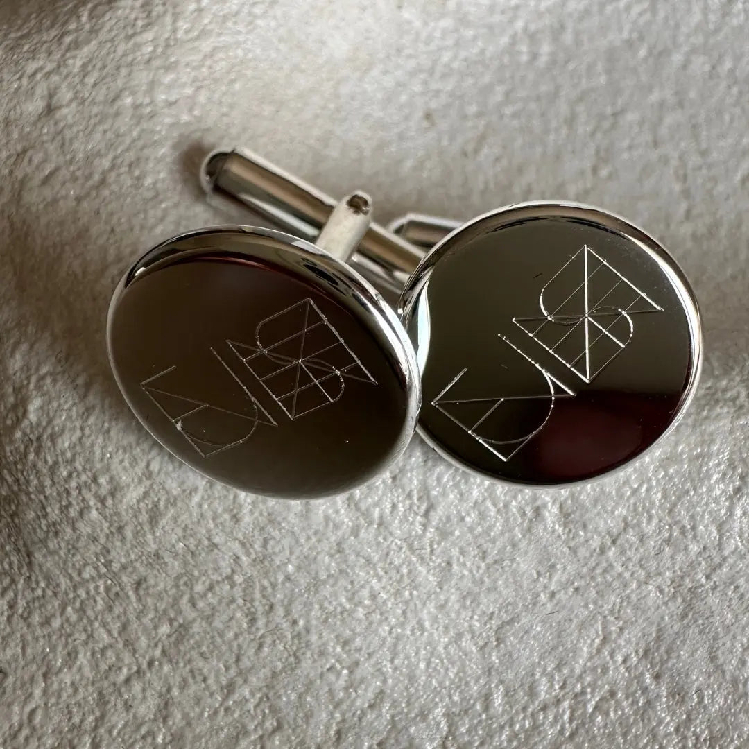 Close-up of Danibydsgn engraved cufflinks in 925 sterling silver featuring a custom logo design.