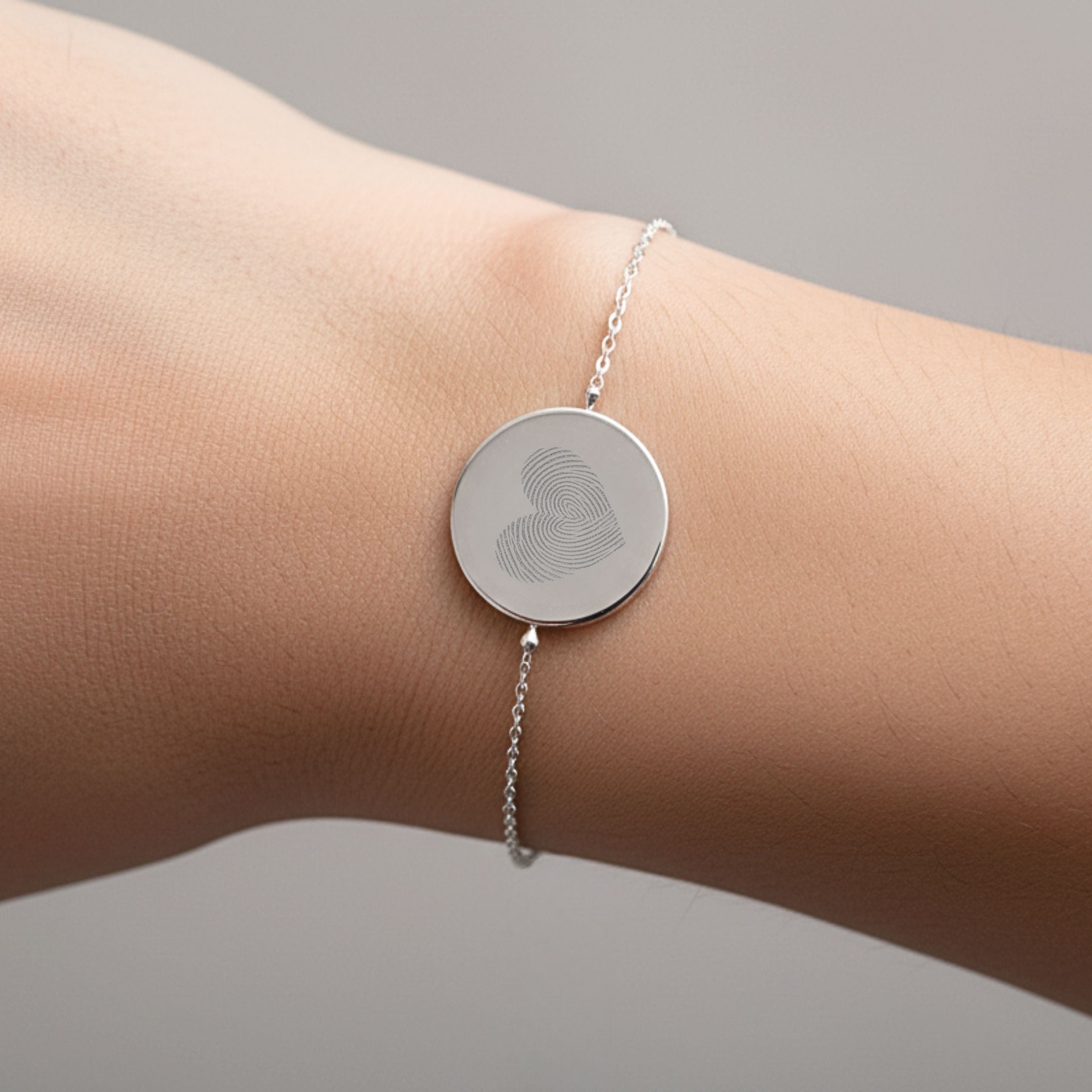 Close-up of the Danibydsgn Heart Fingerprint Coin Bracelet in 925 Sterling Silver worn on the wrist, showcasing a heart-shaped fingerprint engraving that captures love, connection, and cherished memories in a minimalist design.