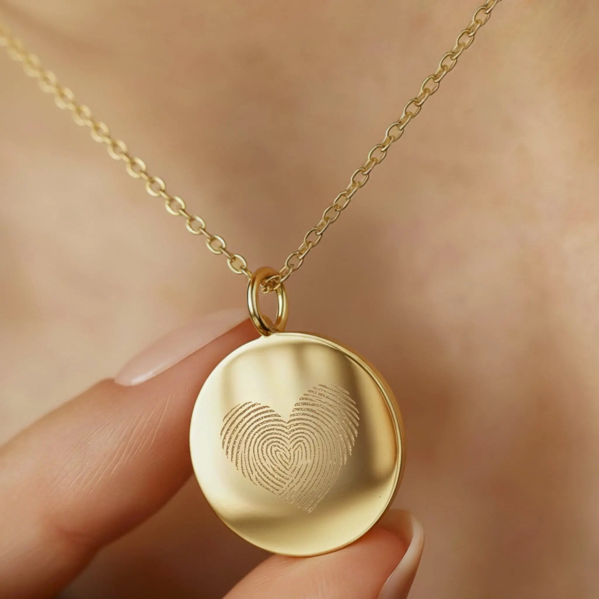 Close-up of the Heart Fingerprint Necklace in 18K Gold Vermeil by Danibydsgn, delicately held near the neckline. The pendant features two fingerprints forming a heart, symbolising love and connection. A fine, handcrafted personalised keepsake made with premium gold vermeil for timeless elegance.