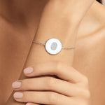 Danibydsgn Single Fingerprint Coin Bracelet in 925 Sterling Silver worn on wrist, showcasing a delicate adjustable chain and 16mm engraved fingerprint pendant that captures a personal connection in a minimalist, timeless design.