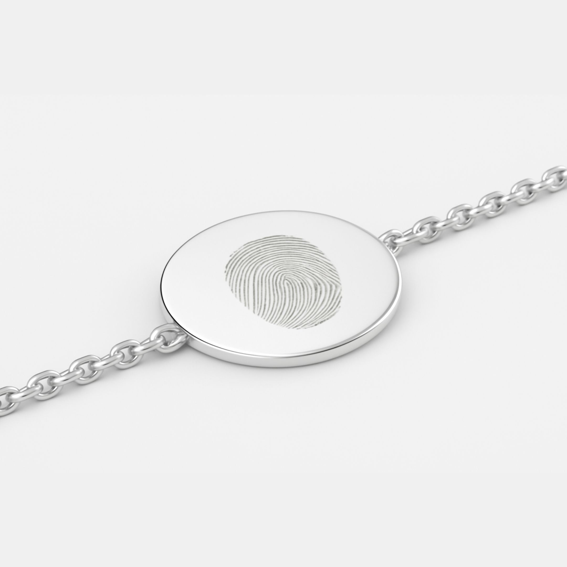 Minimal close-up of the Danibydsgn Single Fingerprint Coin Bracelet in 925 Sterling Silver, showing the engraved fingerprint design on a 16mm circular pendant connected to a fine chain, highlighting its smooth polish and elegant craftsmanship.