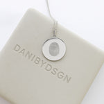 Danibydsgn Single Fingerprint Pendant Necklace in 925 Sterling Silver displayed on branded packaging — showcasing the intricate engraved fingerprint design and minimalist luxury craftsmanship that defines personalized keepsake jewelry.
