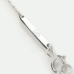 Close-up of the Danibydsgn 925 Sterling Silver bracelet branded clasp tag engraved with “DD”, showcasing the polished finish, fine craftsmanship, and minimalist chain detail for a luxury personalized jewelry touch.