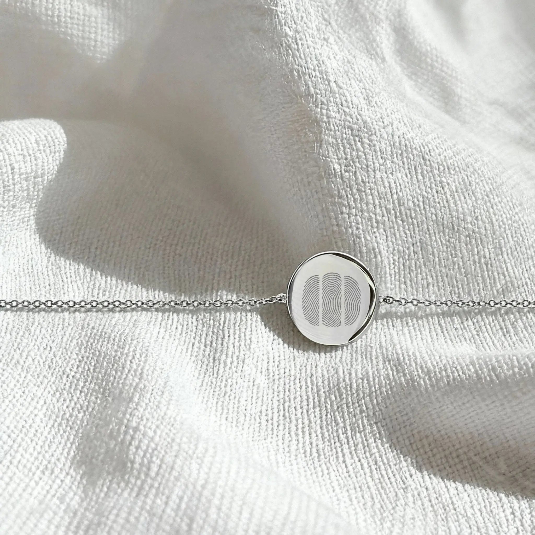 Three Fingerprint Coin Bracelet in 925 Sterling Silver by Danibydsgn, displayed in a flatlay arrangement.