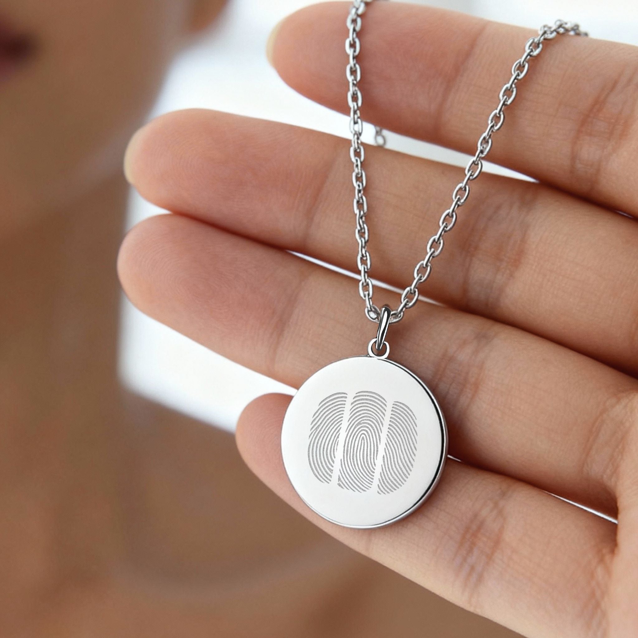 Close-up of the Danibydsgn Three Fingerprint Pendant Necklace in 925 Sterling Silver, showing three precisely engraved fingerprints on a polished coin pendant — a handcrafted piece symbolizing family, unity, and enduring love.