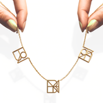 danibydsgn three symbol necklace held up by elegant fingers – personalized 9k yellow gold triple pendant necklace, luxury custom name necklace, bespoke custom jewelry