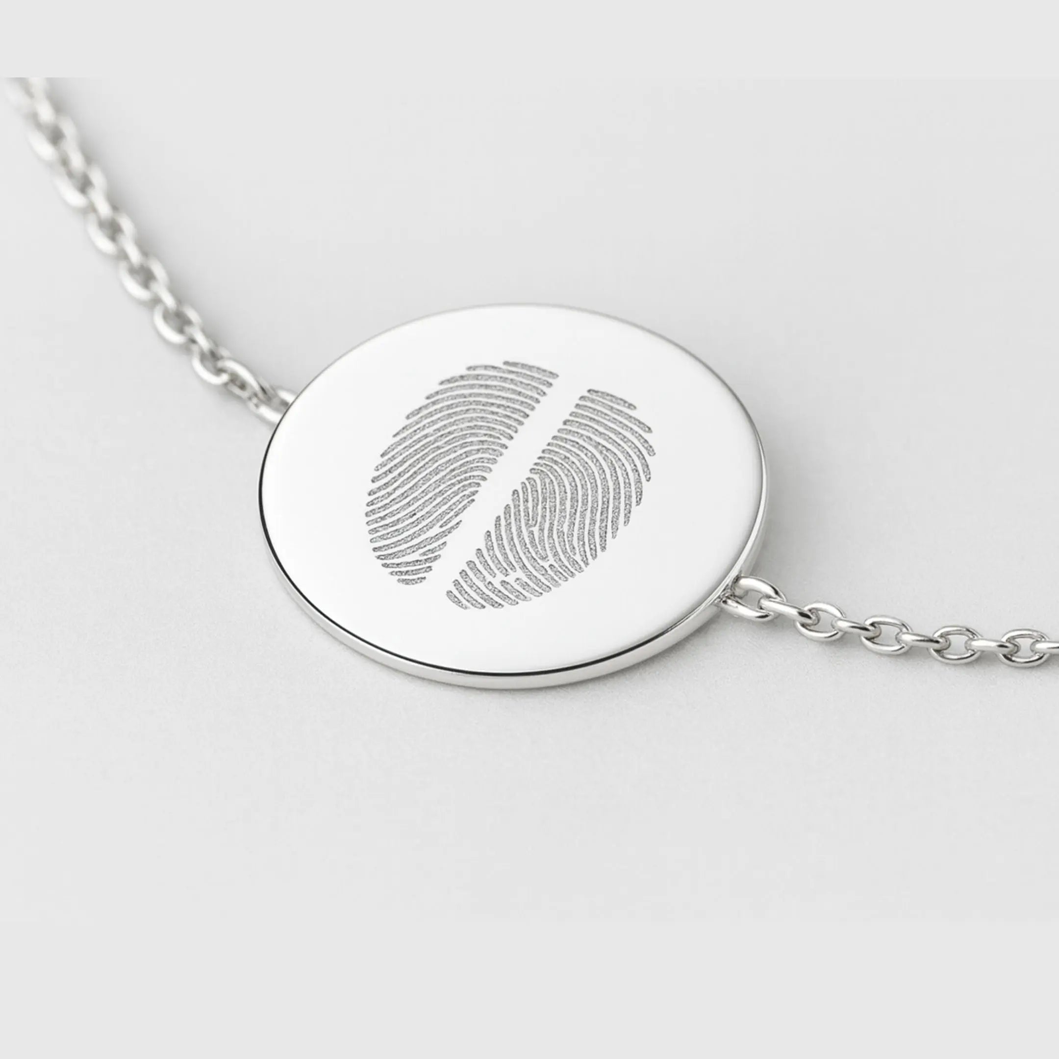 Close-up of the Danibydsgn Two Fingerprint Coin Bracelet in 925 Sterling Silver, showing a detailed view of the polished 16mm pendant engraved with two fingerprints, highlighting fine craftsmanship and elegant chain links.