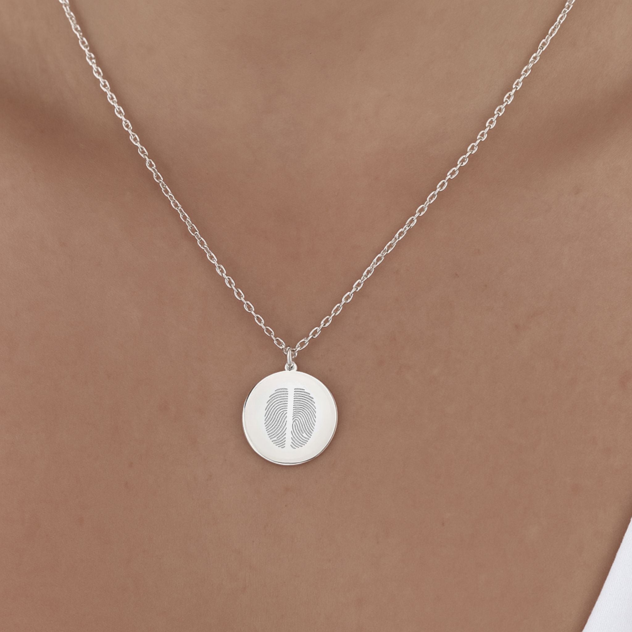 Model wearing the Danibydsgn Two Fingerprint Pendant Necklace in 925 Sterling Silver, featuring two engraved fingerprints on a polished coin pendant that rests gracefully on the collarbone — a modern keepsake of love and connection.