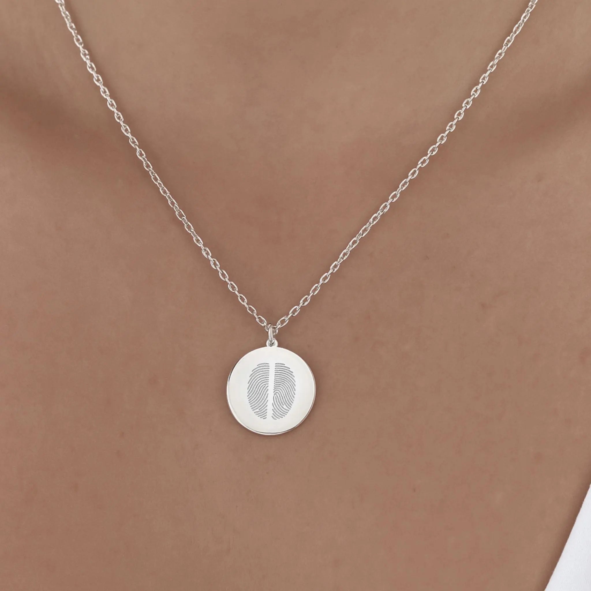 Model wearing the Danibydsgn Two Fingerprint Pendant Necklace in 925 Sterling Silver, featuring two engraved fingerprints on a polished coin pendant that rests gracefully on the collarbone — a modern keepsake of love and connection.