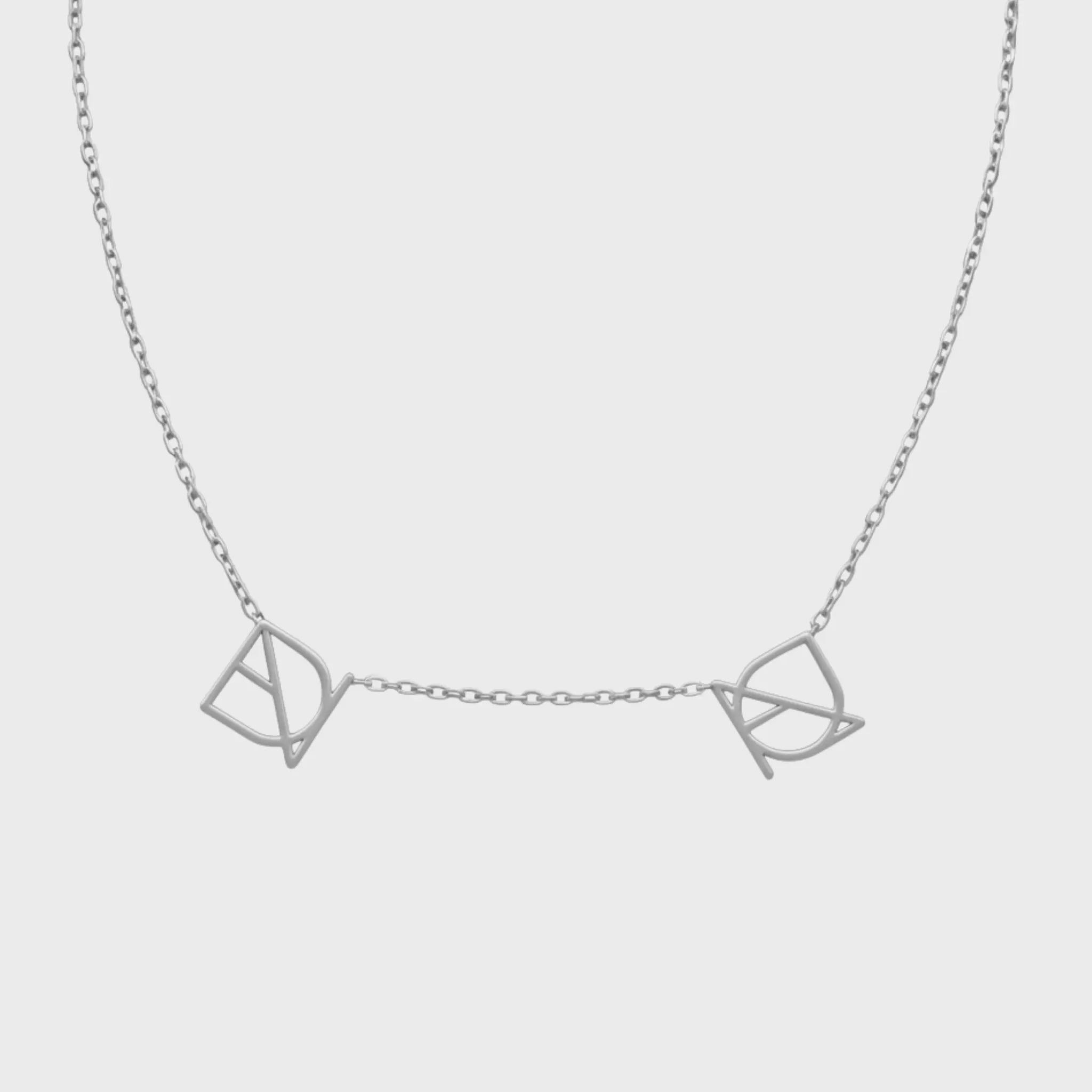 Danibydsgn two-symbol necklace in 925 sterling silver, featuring two custom cut-out symbol pendants spaced on a fine chain (front view).