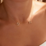 DaniByDsgn two symbol necklace worn on the neck by a lady– personalized 9k yellow gold double symbol pendant, luxury bespoke custom jewelry