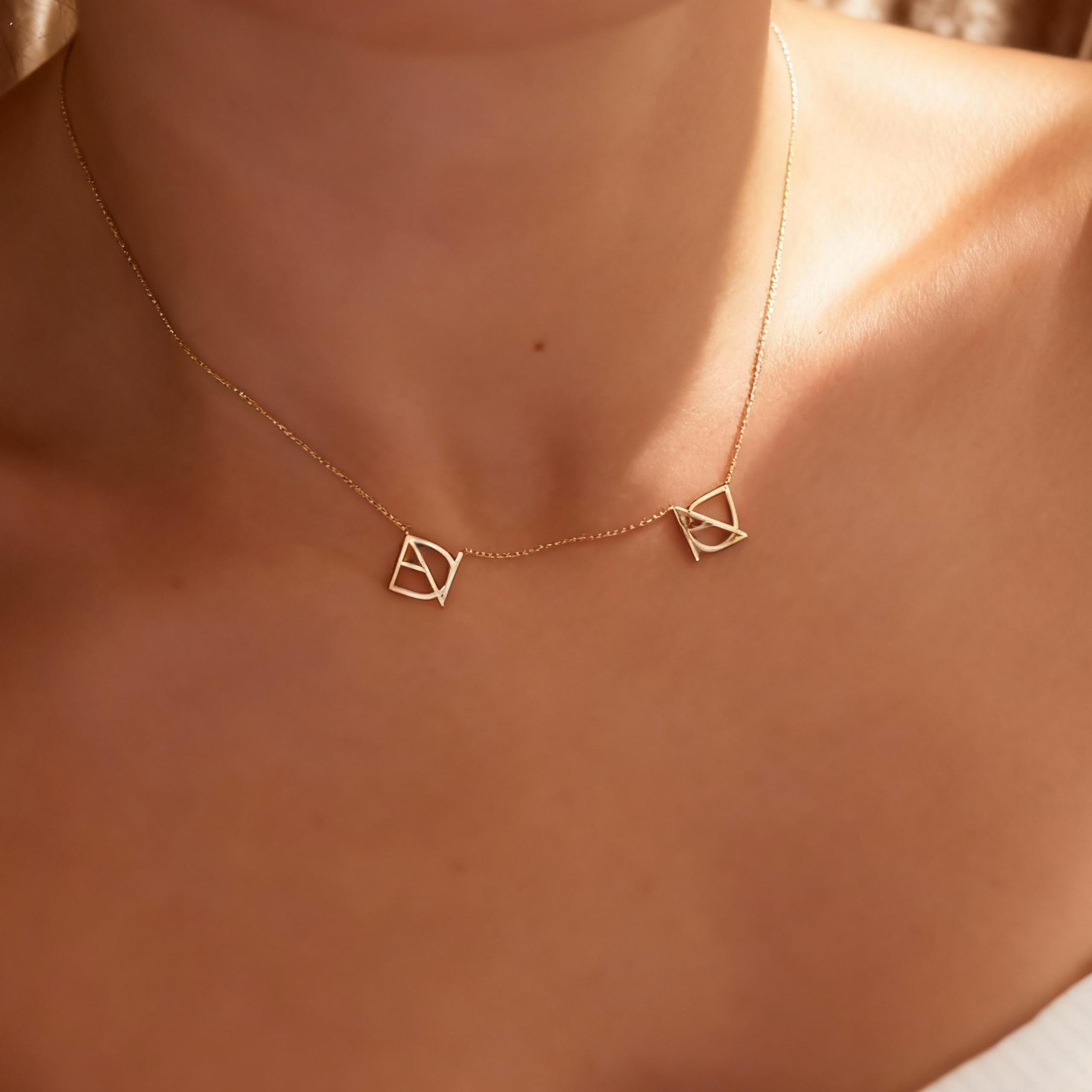 DaniByDsgn two symbol necklace worn on the neck by a lady– personalized 9k yellow gold double symbol pendant, luxury bespoke custom jewelry