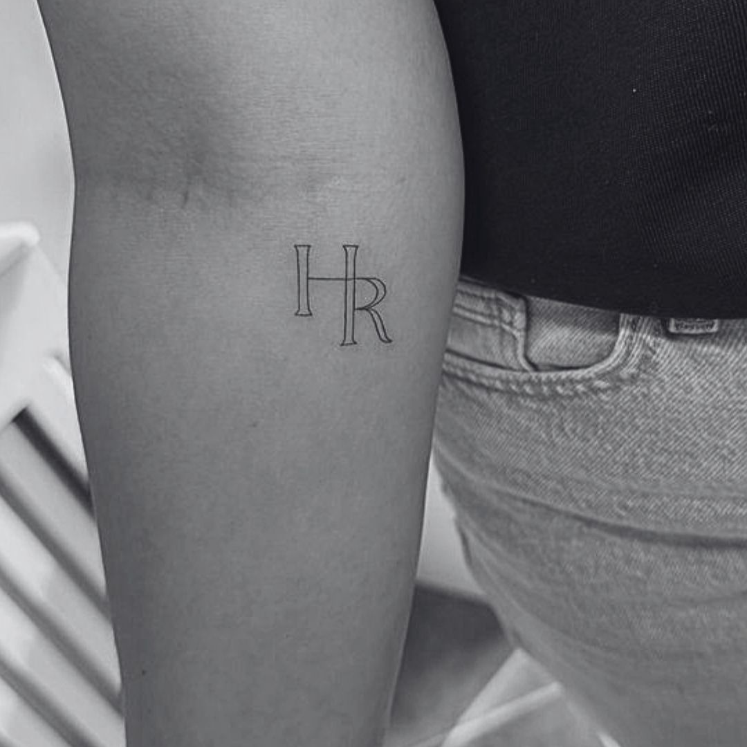 Fine line HR initial monogram tattoo design — minimalist, elegant lettering created by Danibydsgn.