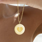 Luxury Heart Fingerprint Coin Necklace in 18K Gold Vermeil by Danibydsgn held gracefully against the neckline. The pendant showcases two fingerprints forming a heart shape, representing love and connection in fine gold craftsmanship — a meaningful personalised jewelry piece for everyday wear or gifting.