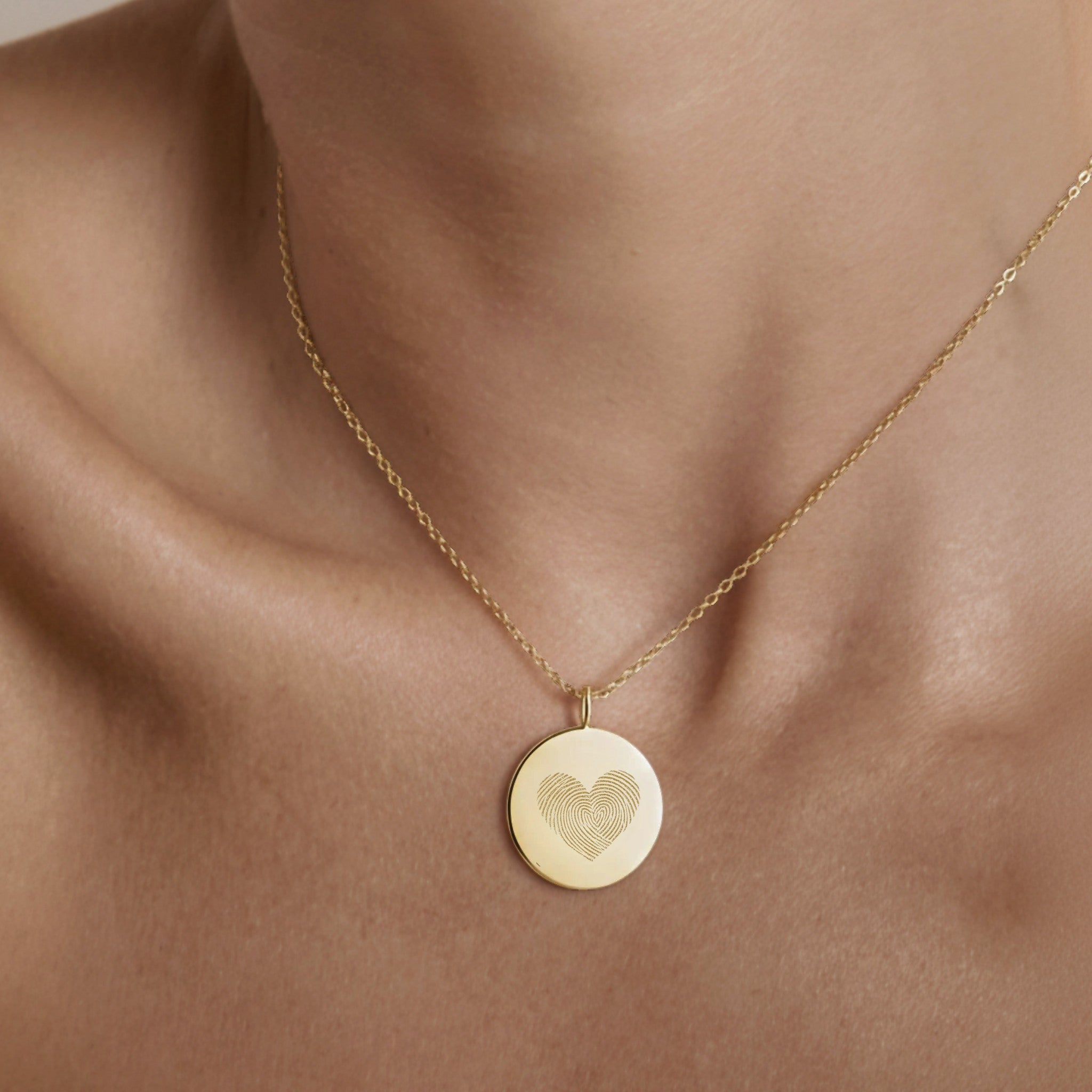 The Luxury Heart Fingerprint Necklace in 18K Gold Vermeil by Danibydsgn shown worn on the neck. Featuring two fingerprints forming a heart shape, this personalised pendant captures love and connection in a minimalist gold design, perfect for everyday elegance or as a meaningful keepsake gift.