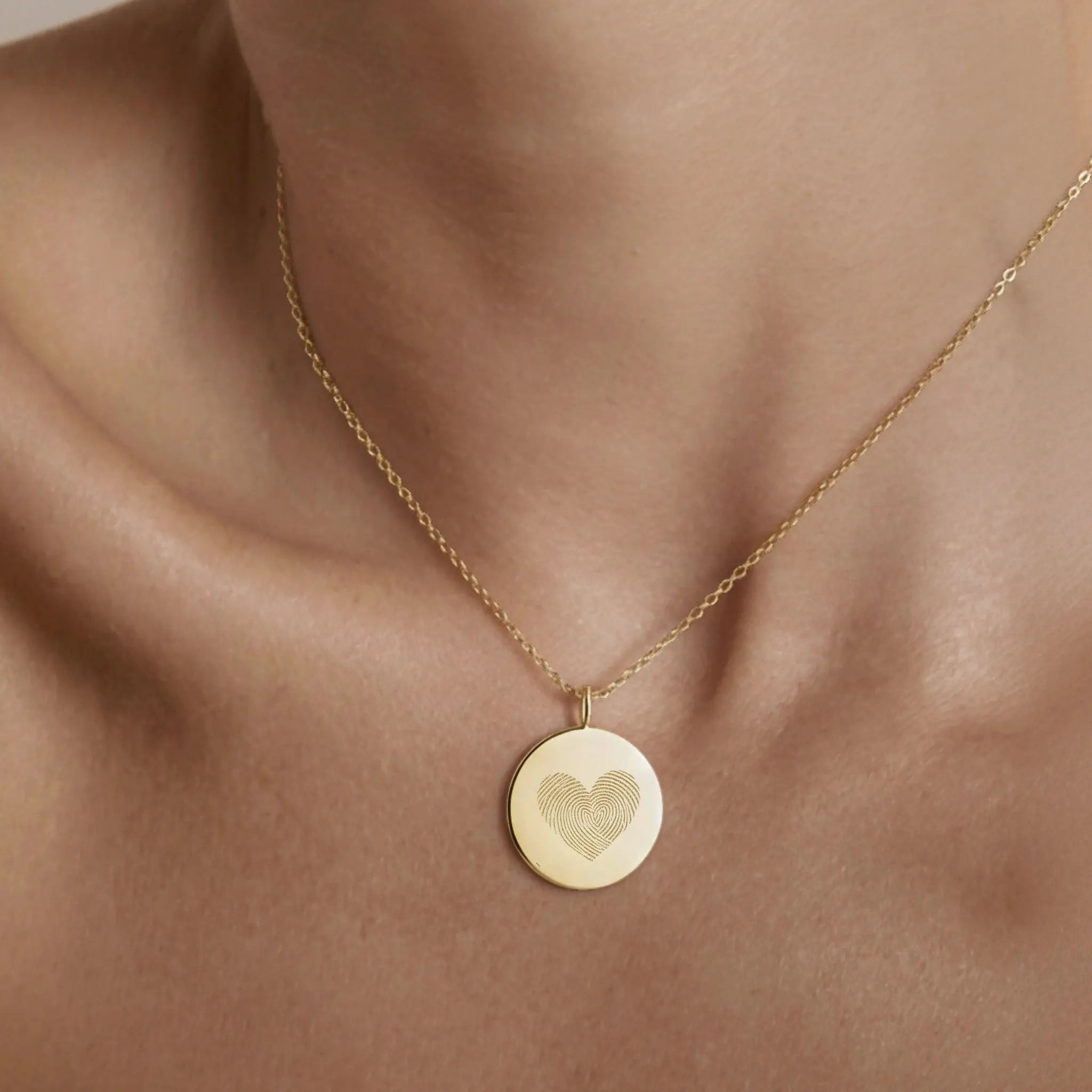 The Luxury Heart Fingerprint Necklace in 18K Gold Vermeil by Danibydsgn shown worn on the neck. Featuring two fingerprints forming a heart shape, this personalised pendant captures love and connection in a minimalist gold design, perfect for everyday elegance or as a meaningful keepsake gift.
