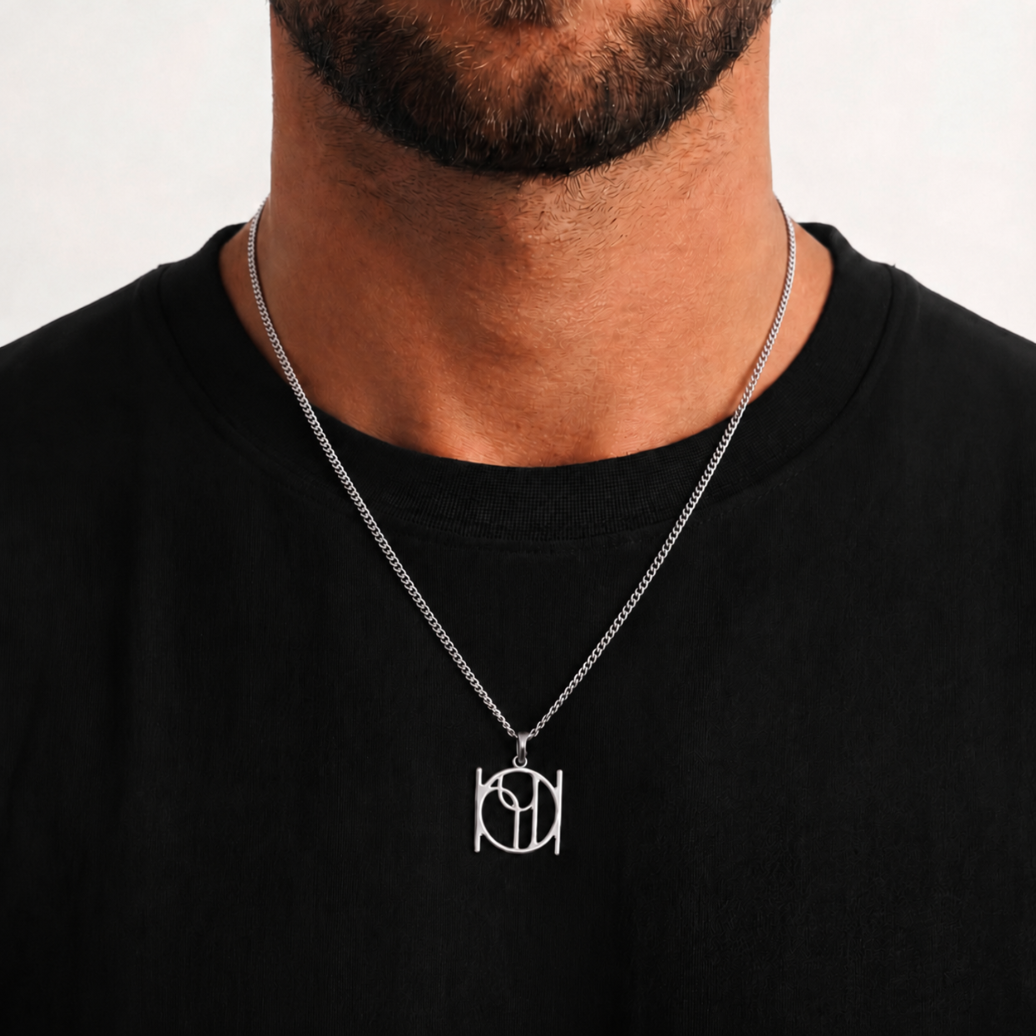 A 925 sterling silver cable chain necklace with a Danibydsgn cut out symbol pendant worn by a man in a black t-shirt against a light gray background.  Adjustable 20-22 inch cable chain which sits chest level. 