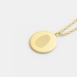 Close-up of the Single Fingerprint Coin Necklace in 18k Gold Vermeil by Danibydsgn — luxury personalized jewelry featuring a detailed fingerprint engraving on a round gold pendant, symbolizing individuality and connection.