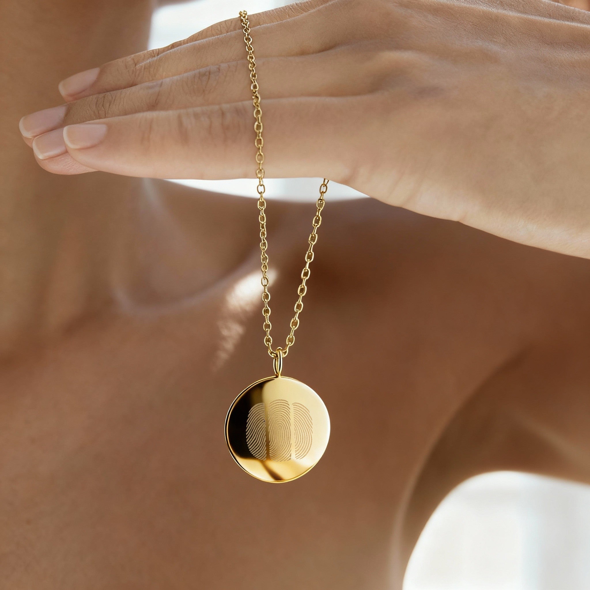 Close-up of the Luxury Three Fingerprint Coin Necklace in 18K Gold Vermeil by Danibydsgn. The pendant’s mirror-polished finish and precision-engraved fingerprints capture a minimalist yet meaningful design, celebrating love, connection, and craftsmanship in fine gold jewelry.