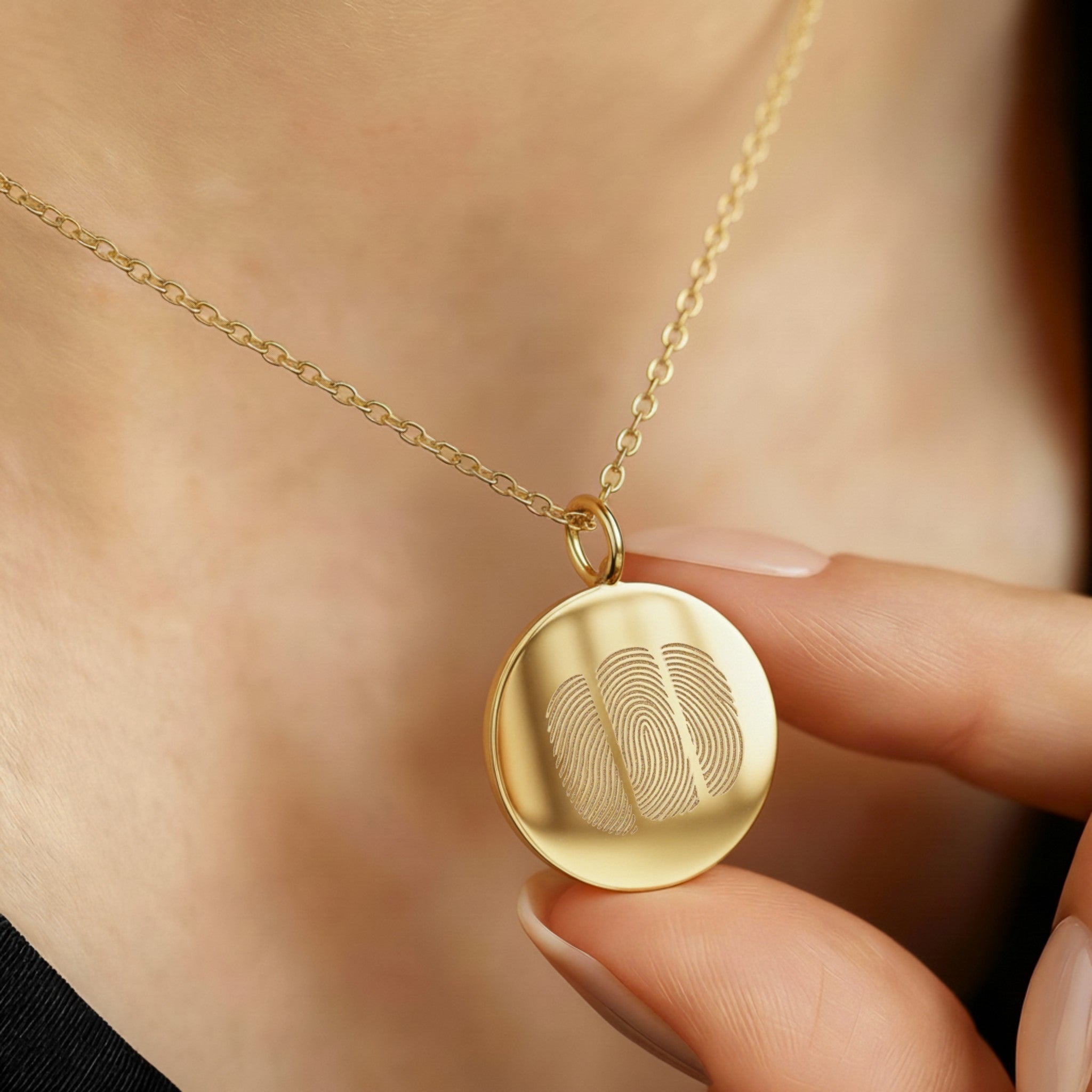 The Luxury Three Fingerprint Coin Necklace in 18K Gold Vermeil by Danibydsgn, shown worn close to the heart. The pendant features three finely engraved fingerprints symbolising love and connection, crafted from radiant gold vermeil for a timeless, heirloom-quality finish.