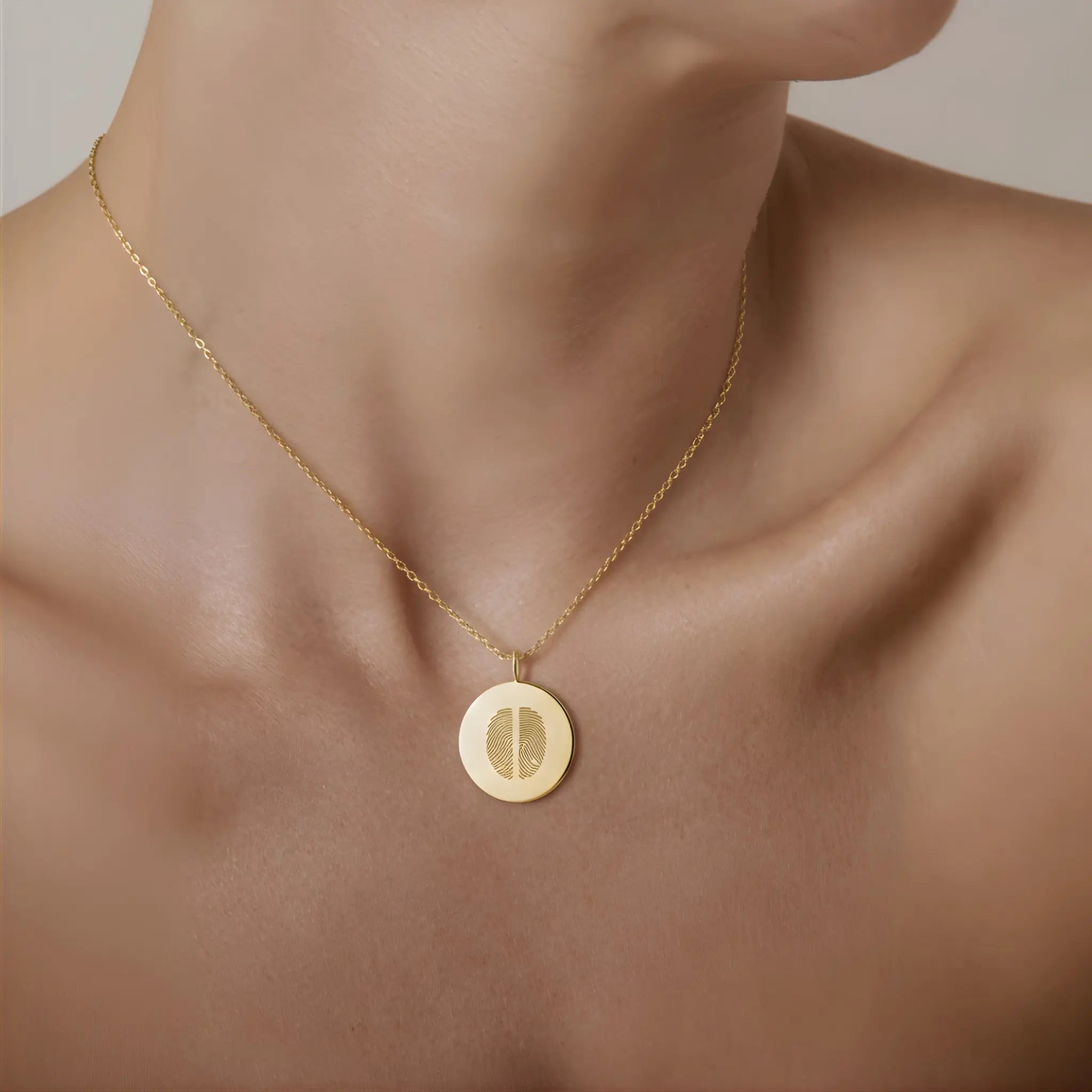 Model wearing the Two Fingerprint Coin Necklace in 18k Gold Vermeil by Danibydsgn — a luxury personalized necklace featuring two engraved fingerprints on a polished gold 