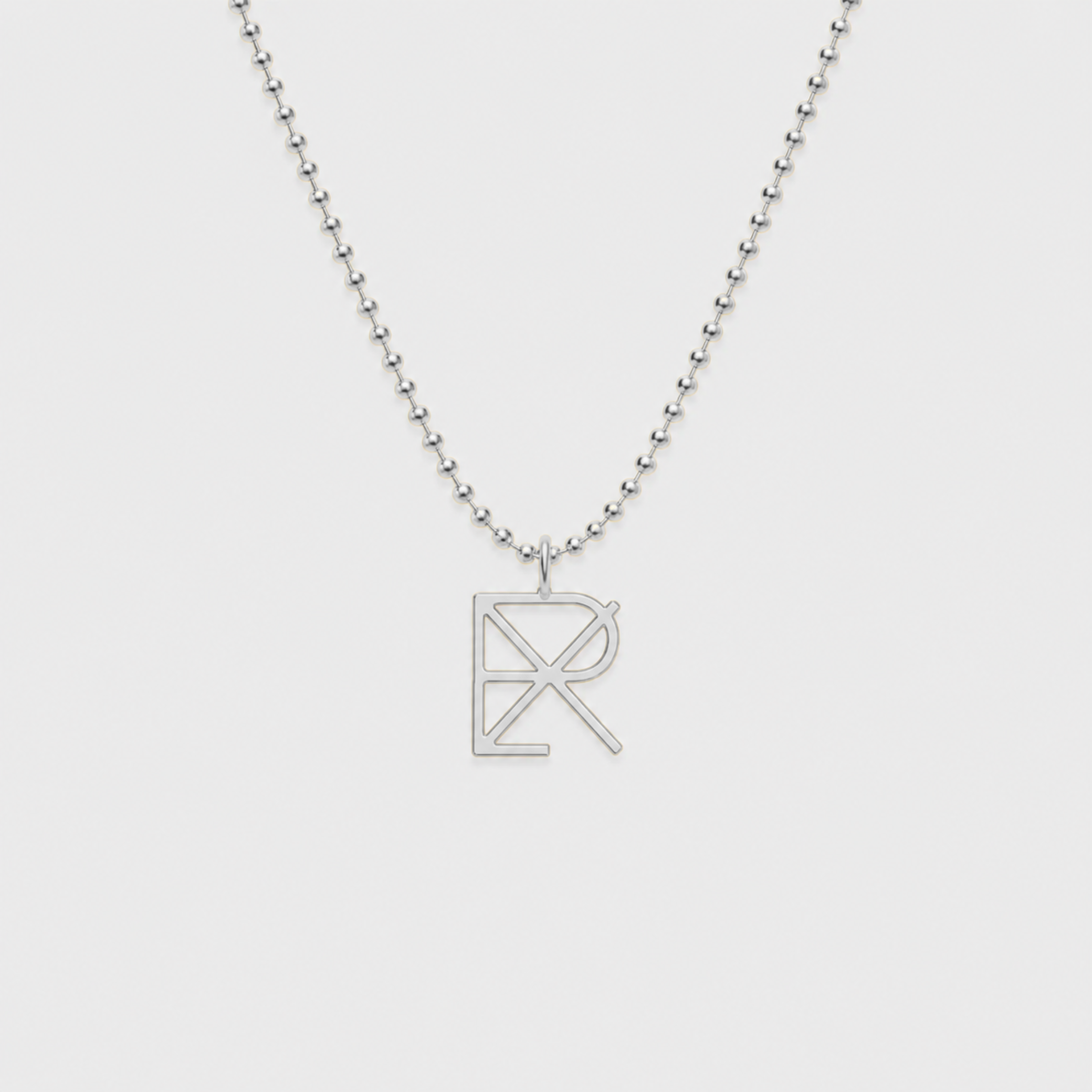 A 925 sterling silver ball chain necklace with a Danibydsgn custom cut out symbol, pendant necklace displayed on a light gray background.  Meaningful jewelry.