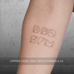 A minimalistic fine line tattoo of an overlapping Custom Logos design on a person's inner arm of a six symbol design in uppercase letters, exemplifying custom logo design, name tattoo design, and body art. This simple tattoo idea showcases personal branding and tattoo art, ideal for both name logos and wall art applications.