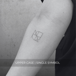 A minimalistic fineline tattoo of an overlapping Custom Logos design on a person's forearm of a single symbol design in uppercase letters, exemplifying custom logo design, name tattoo design, and body art. This simple small tattoo idea showcases personal branding and tattoo art, ideal for both name logos and wall art applications.