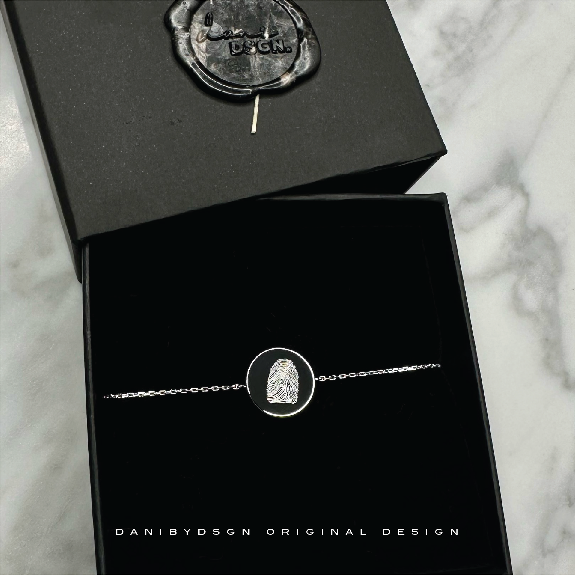 A unique fingerprint engraved jewelry piece that features the actual fingerprint of a loved one, captured in stunning detail for a one-of-a-kind keepsake
