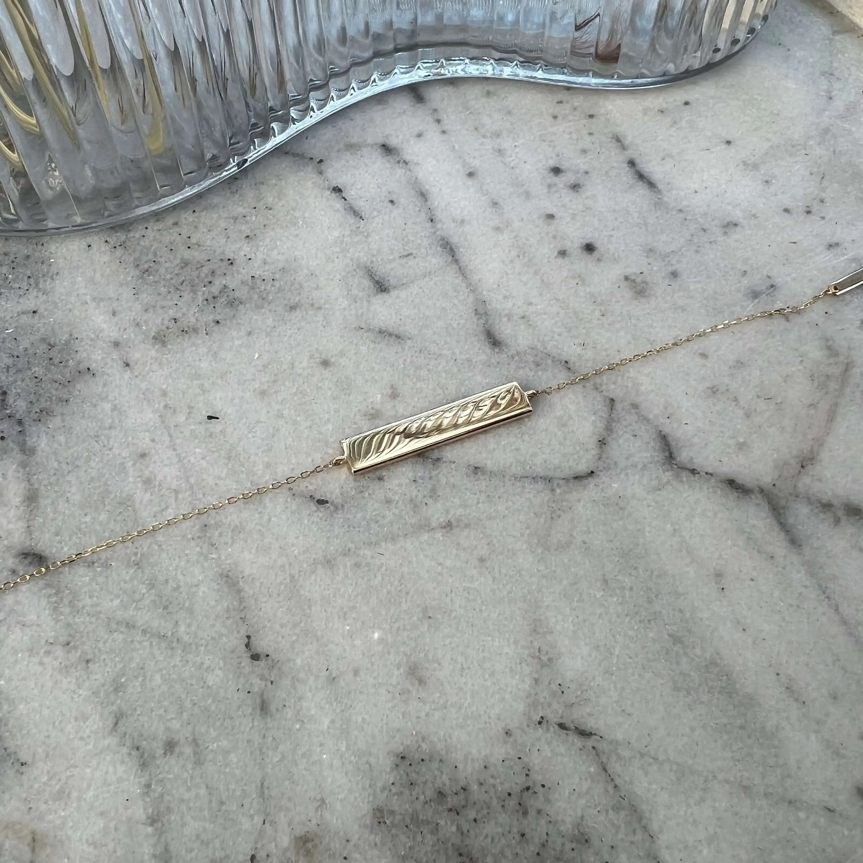 Engravable solid gold bar bracelet by Danibydsgn featuring a sleek design and customizable engraving option.