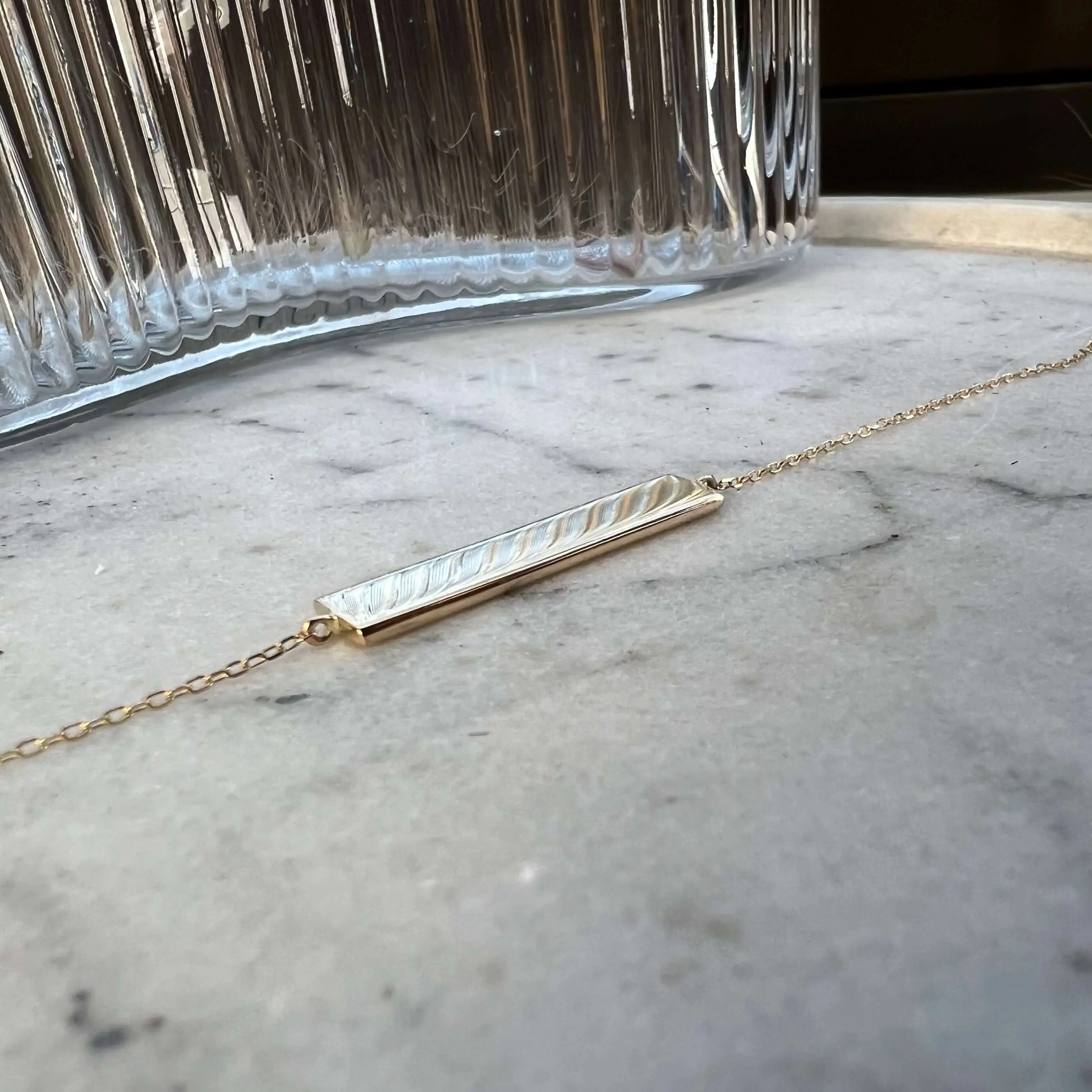 Engravable solid gold bar bracelet by Danibydsgn, showcasing a sleek design with a polished finish.