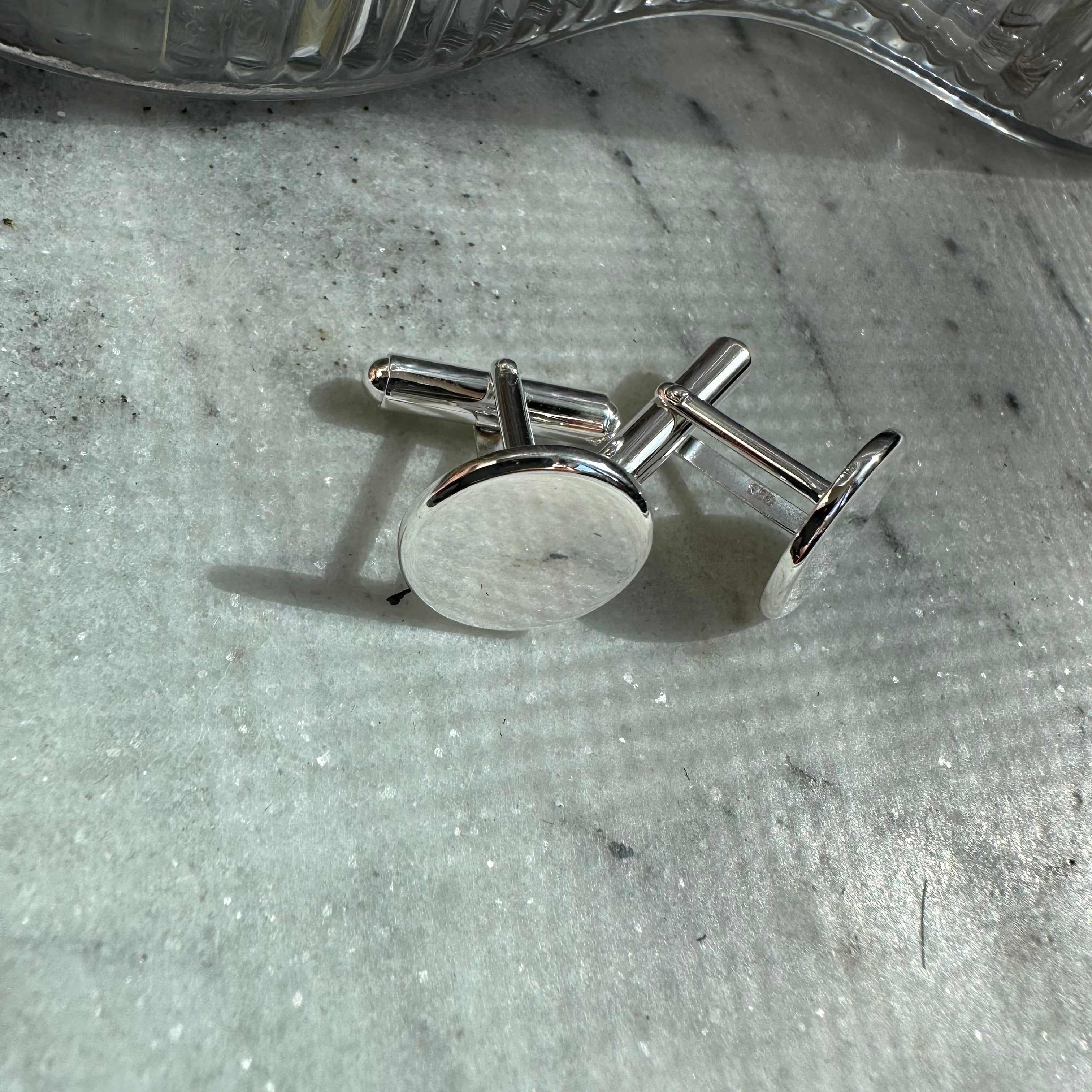 Sophisticated and elegant, our Sterling Silver Cufflinks from the Danibydsgn collection are the epitome of style for the modern gentleman. Ideal for personalizing with a Danibydsgn custom logo or monogrammed, they add a distinctive touch to any ensemble. These cufflinks serve not just as men's jewelry but as a timeless gift for him, reflecting thoughtfulness and elegance. With the option to engrave, these coin cufflinks become a keepsake, encapsulating memories or messages in a subtle yet impactful way.