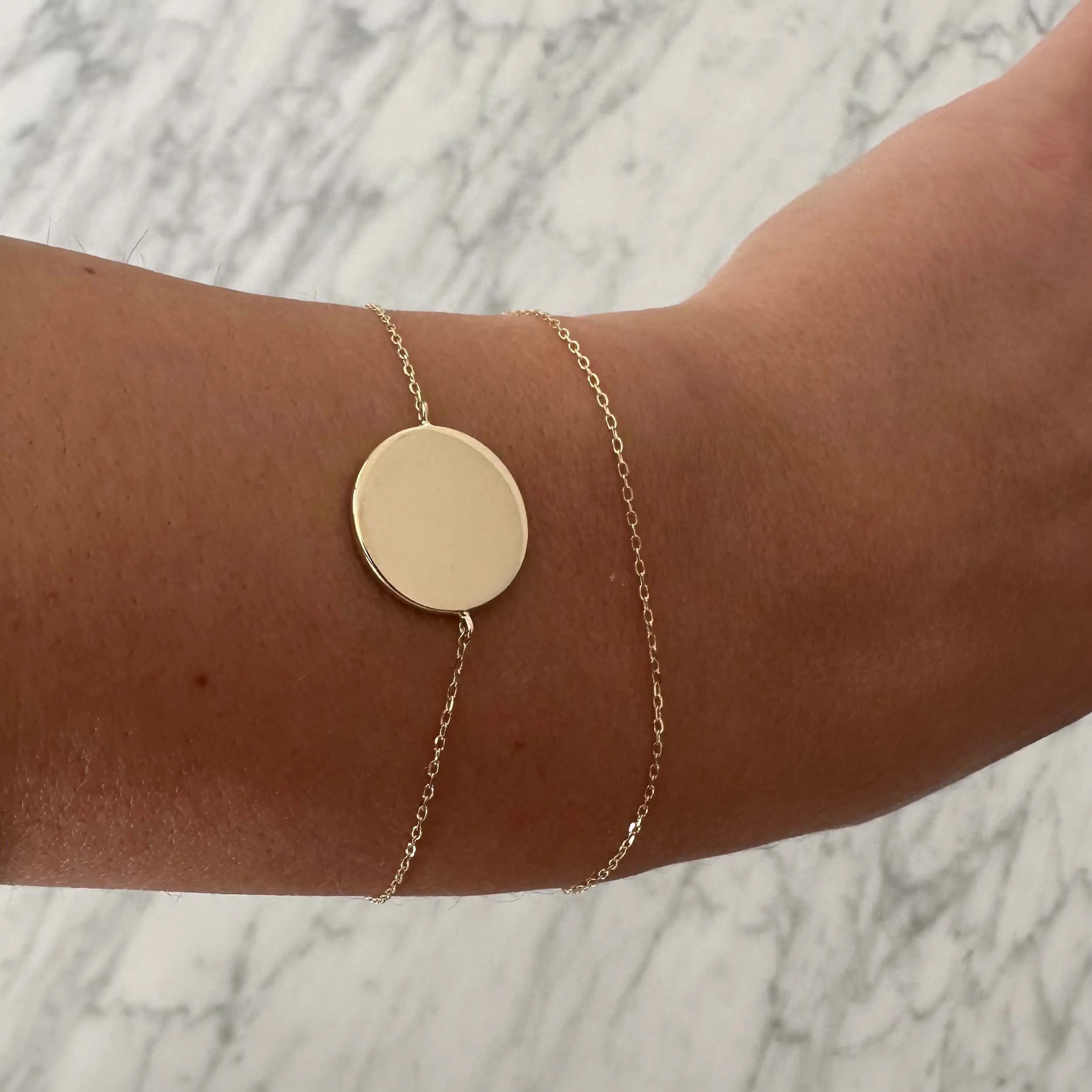 Engravable gold coin bracelet by Danibydsgn featuring a sleek design and customizable charm for personalized style.