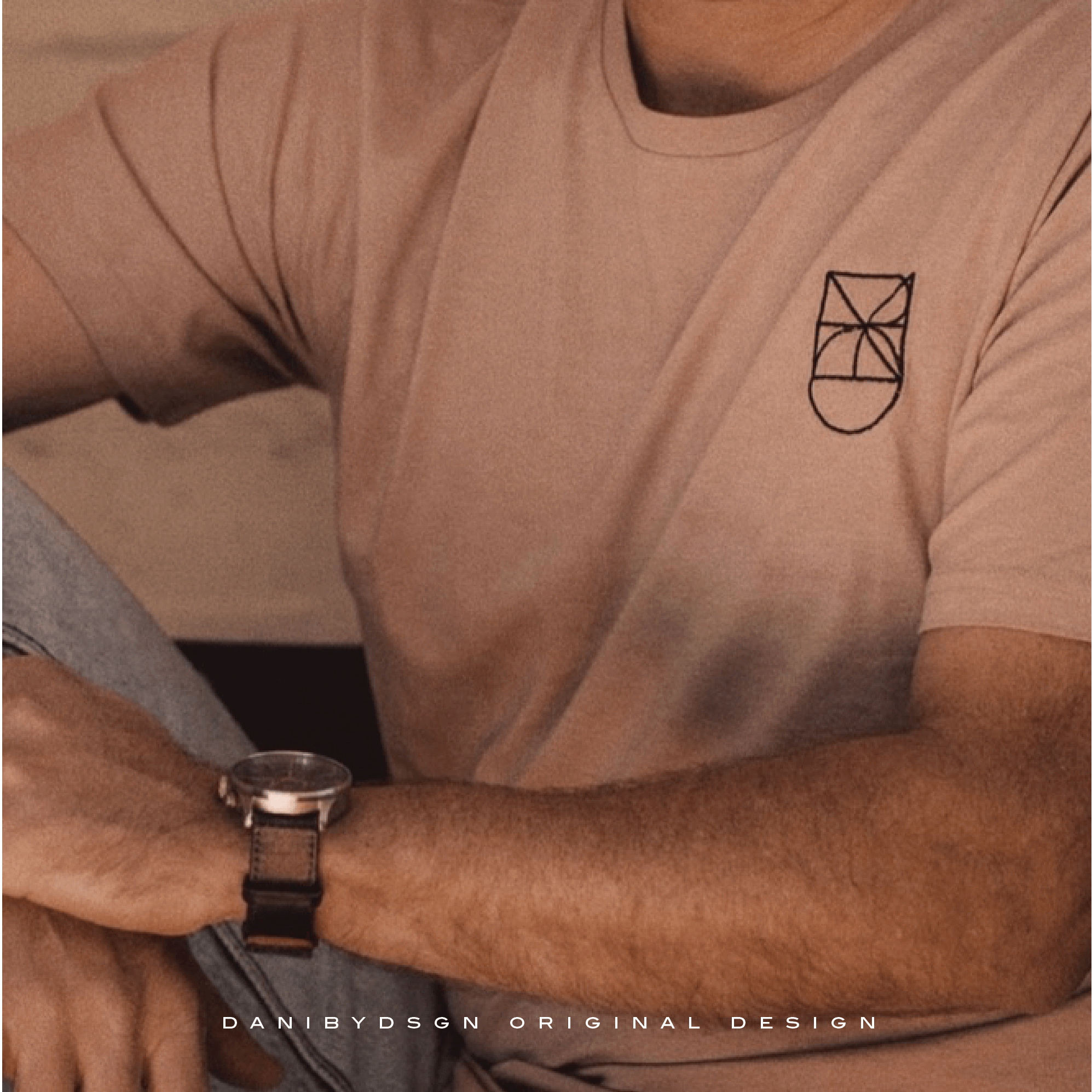 Custom business logo created by Danibydsgn, displayed on a beige t-shirt uniform as part of a complete business branding package showcasing professional brand identity in use.