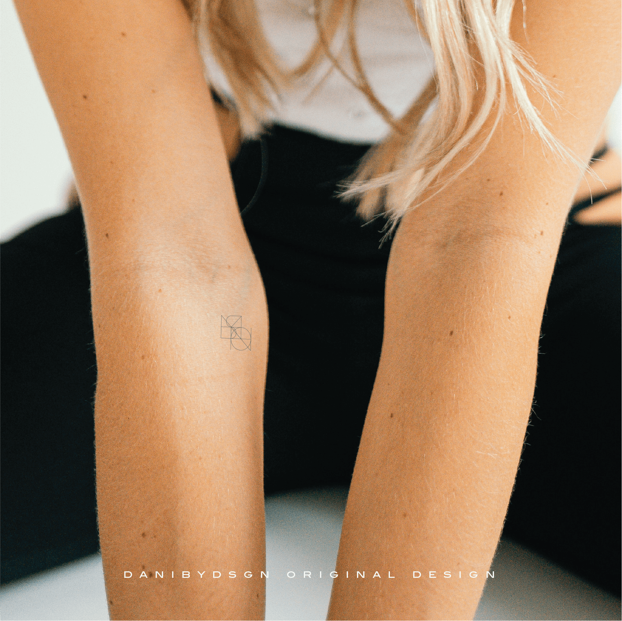 The photo is of a Joined Custom Logo used as a fineline tattoo on the arm of a lady.  The design is a dynamic fusion of two or more symbols into an entwined logo joined diagonally.  The designs are custom names or numbers, ideal for personal branding or as wall art or clothing branding. Custom logo design, translates into a name tattoo design and body art embodying the spirit of simple tattoo ideas while resonating with the artistry of an illustrator.